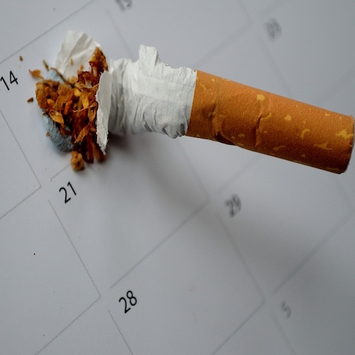 A cigarette crushed out on a calendar square when they stopped smoking
