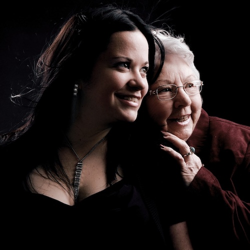 An adult woman smiling happily with her grandmother