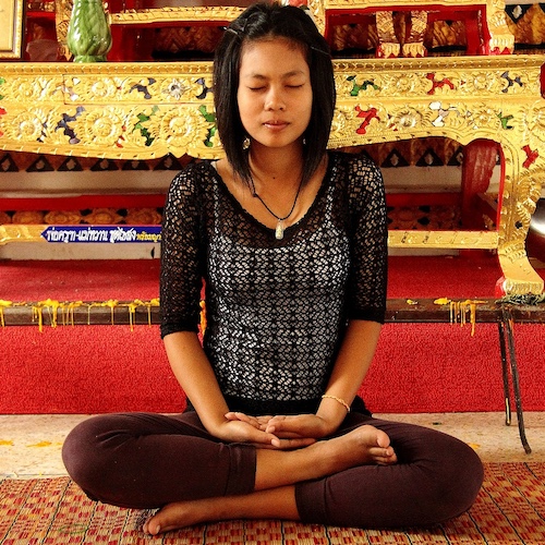 A lady stress-free sitting crosslegged in a yoga pose